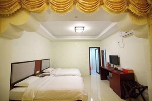 A hotel room with two beds, a desk, and a chair.