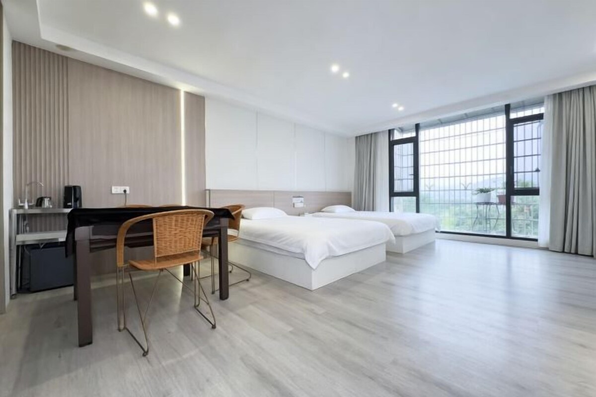 A modern hotel room with a bed, a desk, and a chair.