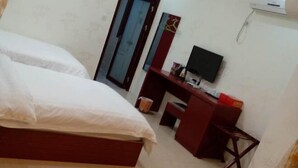 A bedroom with a bed, a desk, a chair, a television, and a wardrobe. - Xiangyuan Hot Spring Hotel (Rucheng)
