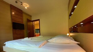 Un lit bien fait, avec du linge de lit blanc, dans une chambre d’hôtel moderne.