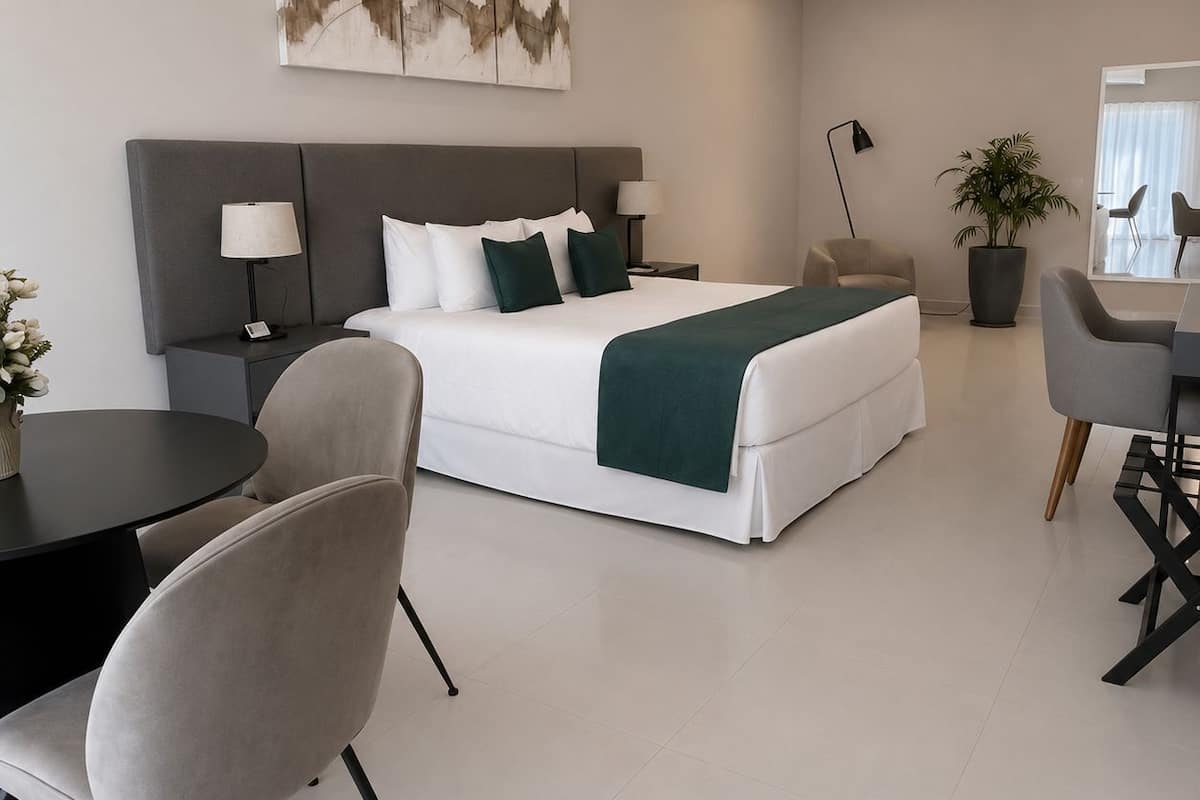 A modern hotel room with a bed, bedside tables, a desk, and a chair.
