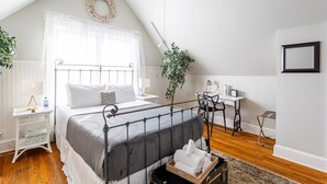 A bedroom with a bed, a desk, a chair, a ceiling fan, and a plant. - Renovated 2BR Retreat / Modern Comforts Included (Bridgeport)