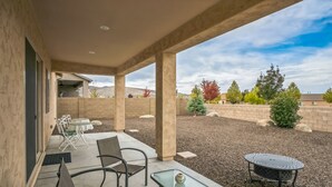 A covered patio area with outdoor seating, including a table and chairs, and a small round table. - Cozy Granville Retreat W/ Modern Amenities 3 Bedroom Home (Prescott Valley)