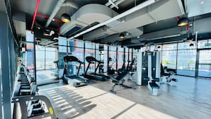 Ein modernes Fitnessstudio mit Laufbändern, Crosstrainern und Kraftstationen.