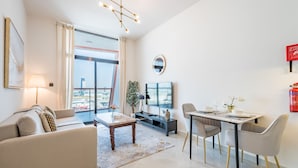 Ein modernes Wohnzimmer mit Sofa, Couchtisch, Fernseher und Essbereich.