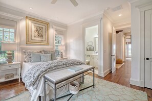 A bedroom with a large bed, bedside tables, a reading bench, and a window with a view of the outdoors. - Enviable location, pool with breathtaking scenery at every turn. (Kiawah Island)