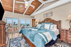 A bedroom with a large bed, wooden ceiling, and a view of the ocean. - Aquarius Oceanside: 9BR/8BA Beachfront w/ Pool, Hot Tub, Elevator & Riverfront (Stuart)