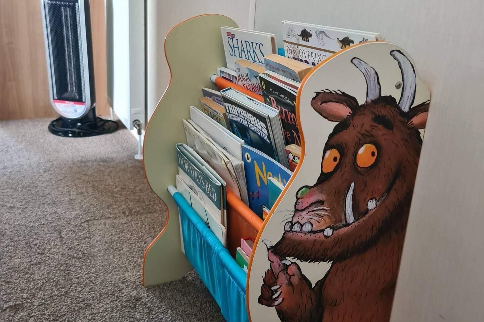 Une bibliothèque avec des livres et un motif représentant un animal de dessin animé.