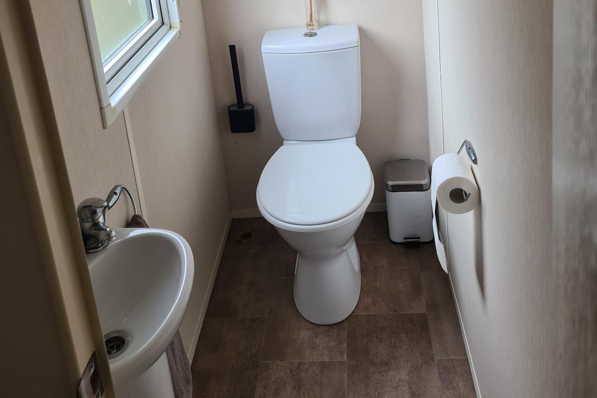 A compact bathroom with a toilet, bidet, and sink.