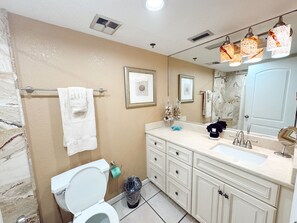 Une salle de bain équipée de toilettes, d’un lavabo, d’un meuble-lavabo et d’un porte-serviettes.