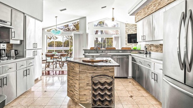 A modern kitchen with a central island, stainless steel appliances, and a view to the outdoors.