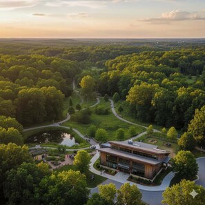 A modern building surrounded by lush greenery and a winding path.