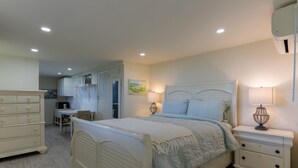 A bedroom with a bed, nightstands, a dresser, and a desk with a chair. - Studio apartment above Horseshoe Bay beach (Southampton Parish)