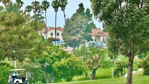A golf course with a clubhouse in the background, surrounded by trees and a clear sky. - New Remodel, Minutes to Beach, Perfect for 2 (Long Beach)