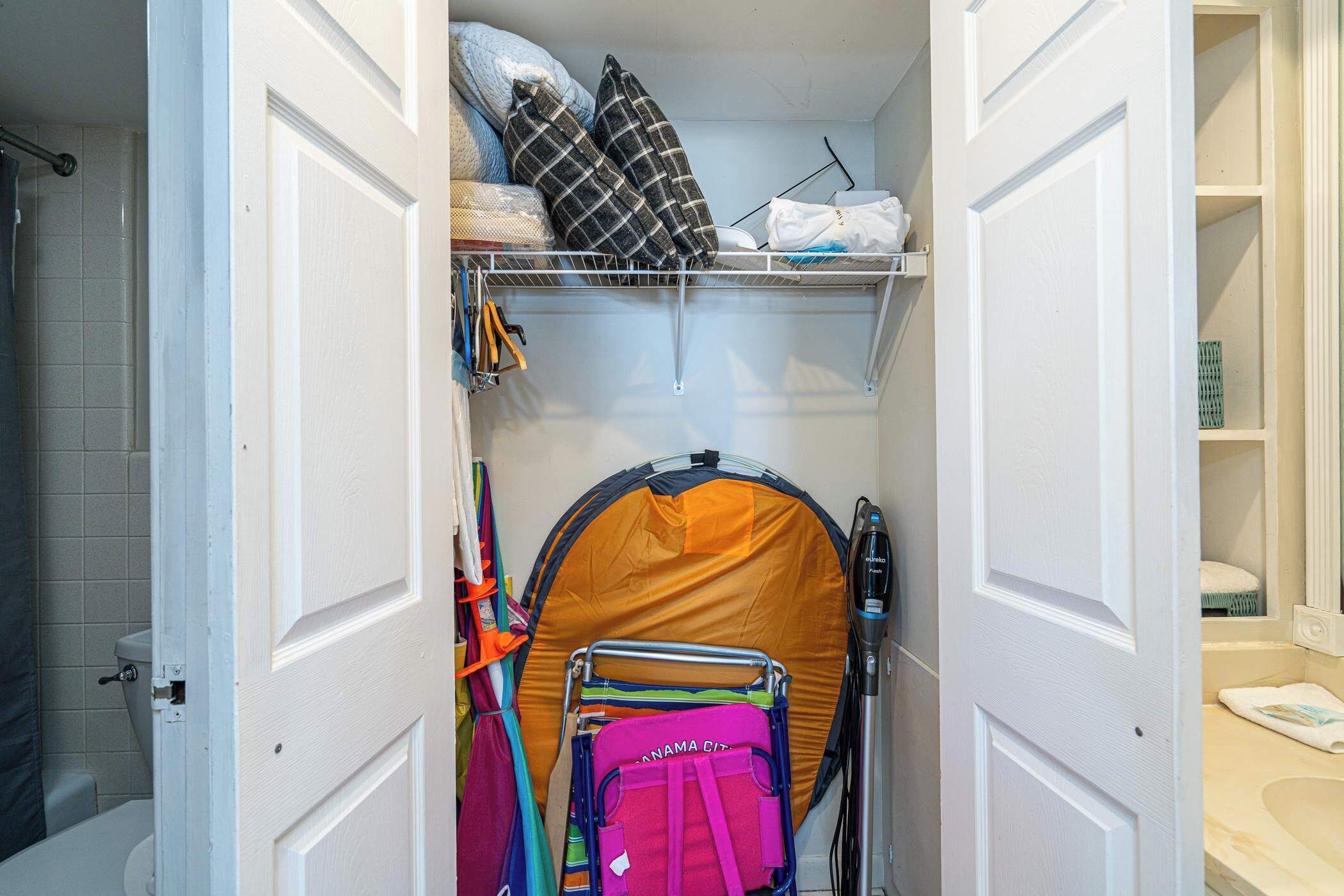 Un espace de rangement compact comprenant une tente pliable, un étendoir et un porte-parapluie.