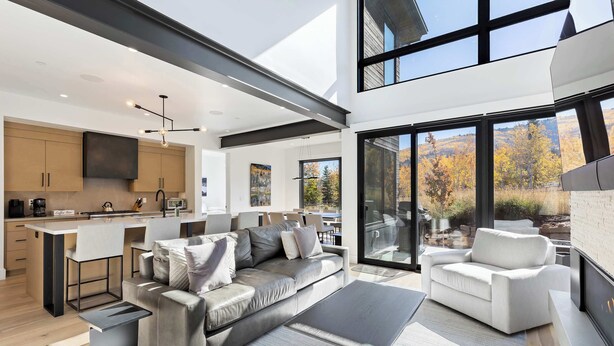 Een modern interieur met een bank, salontafel en eethoek.