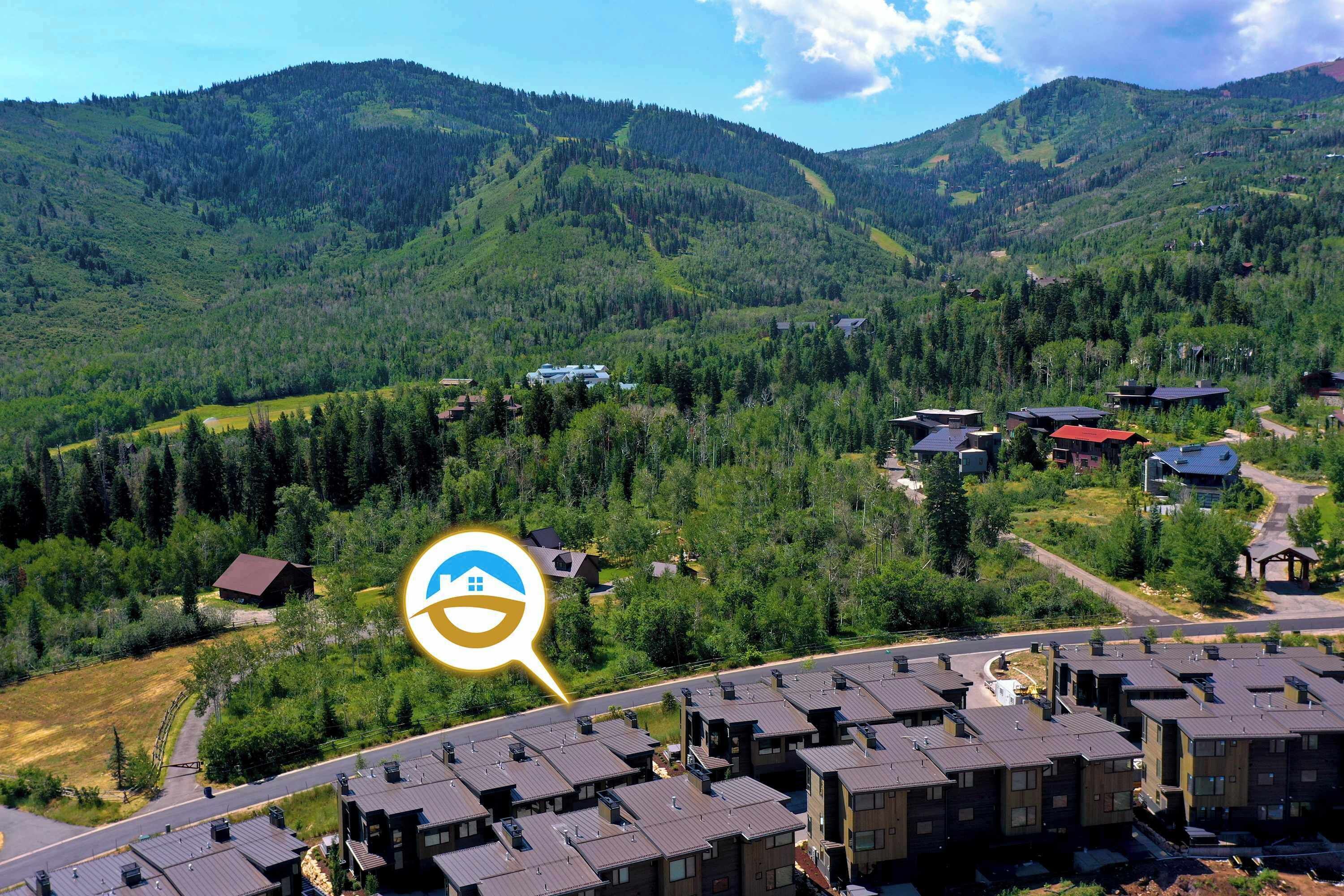 Zona residencial con modernos edificios de apartamentos, una carretera y un paisaje montañoso al fondo.