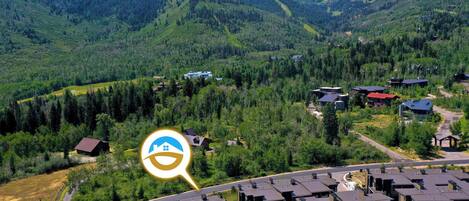 Zona residencial con modernos edificios de apartamentos, una carretera y un paisaje montañoso al fondo.
