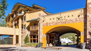 Un edificio con fachada de piedra y un arco amarillo con la leyenda "SUNDIAL LODGE".