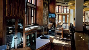 Un restaurant doté d’un long comptoir, de lambris en bois et de grandes fenêtres.