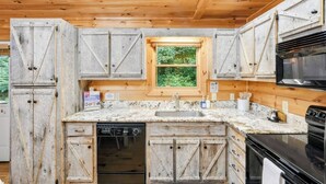 A kitchen with wooden cabinets, a window, a sink, a dishwasher, and a stove.