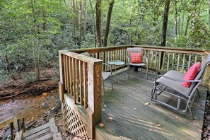 A wooden deck with a railing, two chairs, and a small table. - Cabin in Blue Ridge Hot Tub, Games, & Creek! (Blue Ridge)