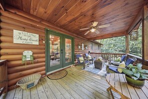 A wooden cabin with a covered porch, a welcome sign, and outdoor seating. - Cabin in Blue Ridge Hot Tub, Games, & Creek! (Blue Ridge)