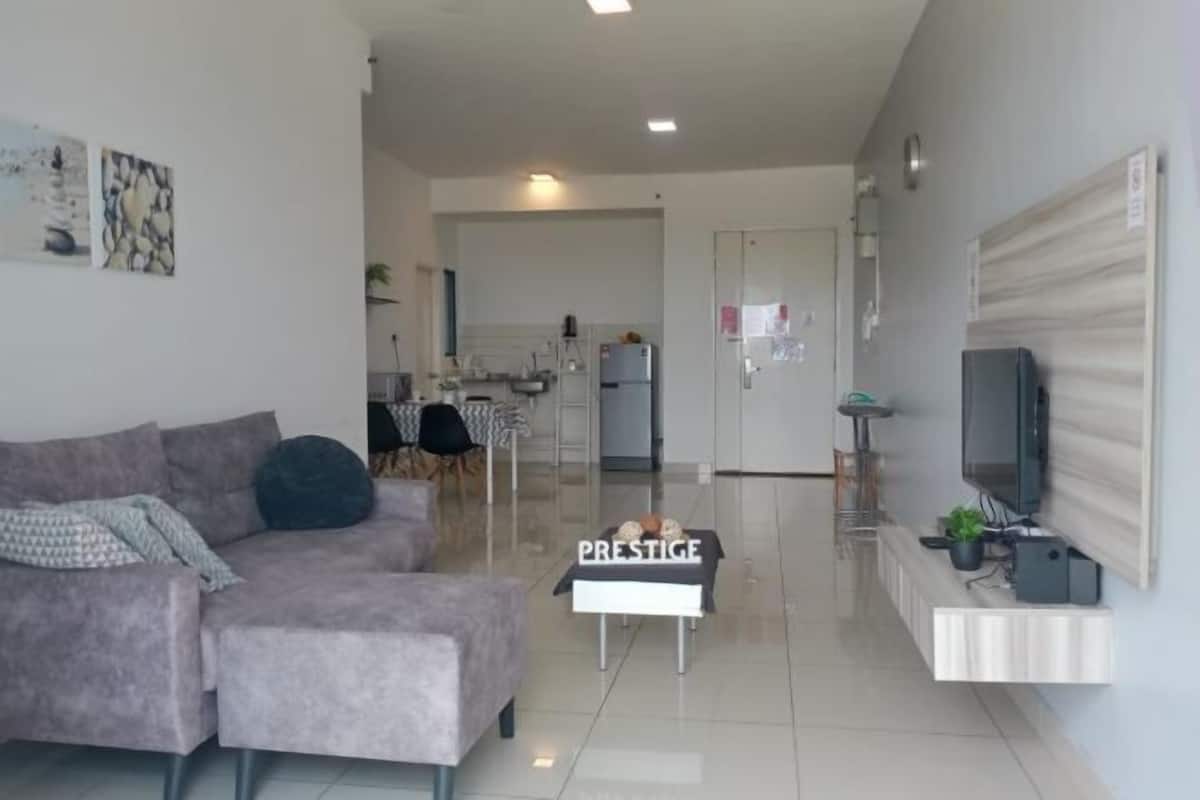 Una sala de estar moderna con un sofá gris, una mesa de centro y un televisor en un mueble de pared.