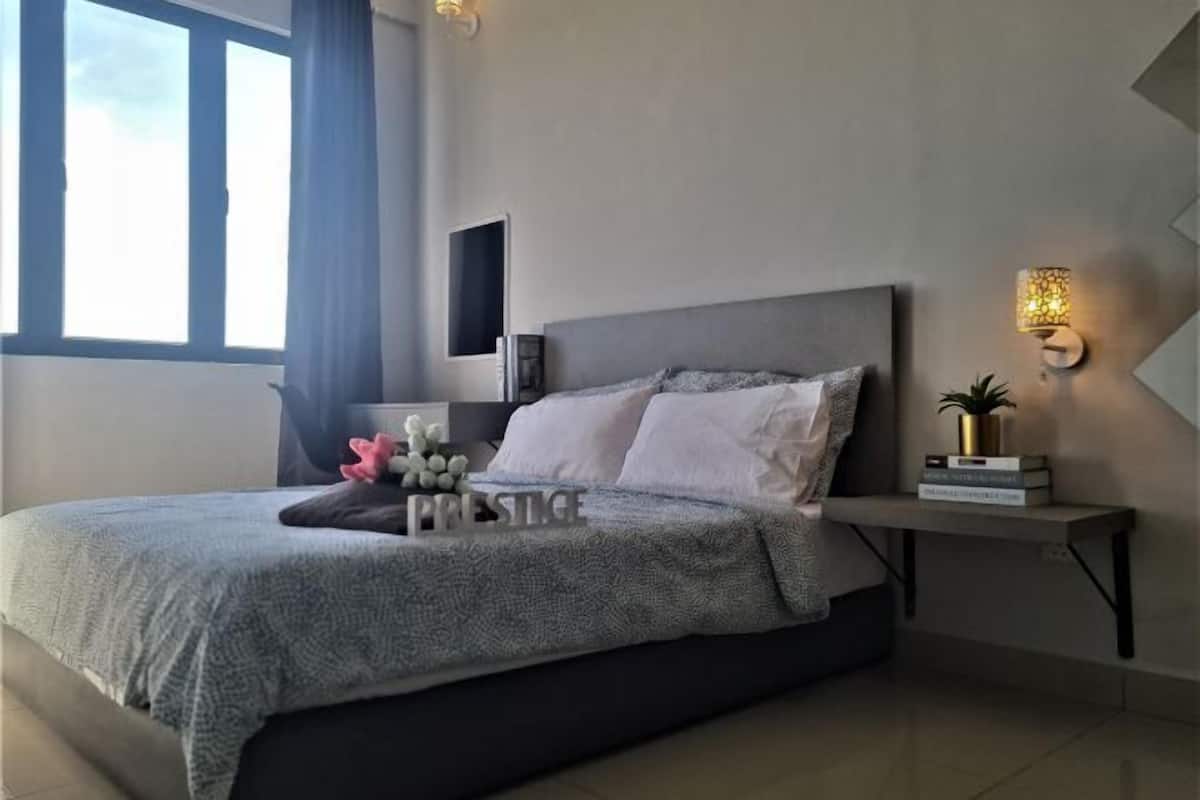 Un dormitorio moderno con cama, mesita de noche, lámpara y ventana.