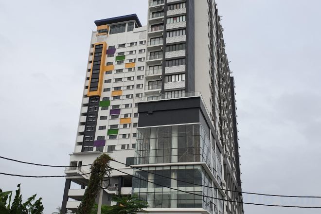 Un edificio de varios pisos con un diseño arquitectónico moderno, que combina elementos de fachada de vidrio y paneles sólidos.