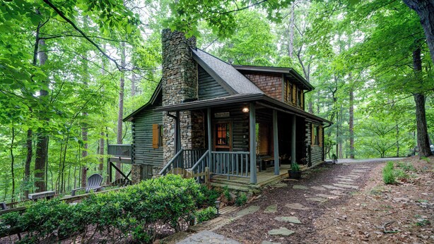 A log cabin with a stone chimney, wooden porch, and a stone pathway leading to the entrance. - The Guest Cabin - Historic Home in Big Canoe (Big Canoe)