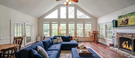 A spacious living room with a large sectional sofa, a fireplace, and a television.
