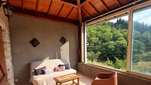 Ein gemütliches Zimmer mit Holzbalkendecke, einem Bett, einem kleinen Tisch und zwei Stühlen.
