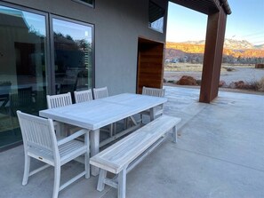A white wooden table and benches set on a concrete patio with a mountain view. - Panoramic Views I Open Concept Floorplan I Private Hot Tub I Ample Parking (Moab)