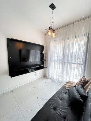 Studio – basic, balkong, byutsikt | Oppholdsområde | En 50-tommers smart-TV med digitale kanaler