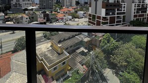 A high-rise building with multiple floors and balconies, surrounded by other buildings and a clear sky. - Apto 1 dormitório no Brooklin (São Paulo)