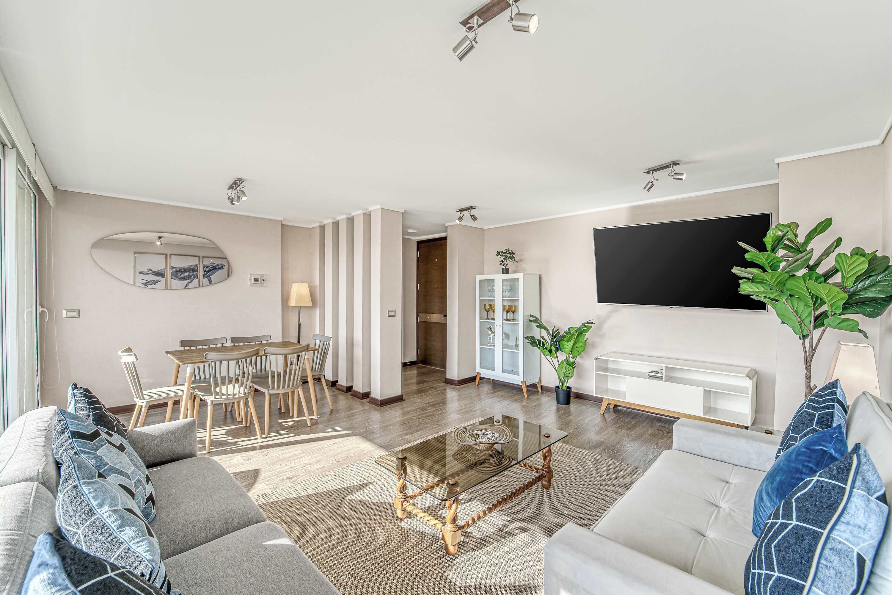 Ein Wohnzimmer mit Sofa, Couchtisch, Fernseher und Essbereich.