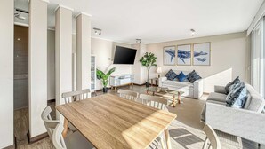 A modern living room with a dining area, a sofa set, a flat-screen TV, and a staircase. - Costa Vina 3B  Balcony & View (Viña del Mar)