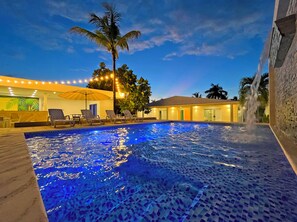 A swimming pool with a tiled deck, lounge chairs, and a palm tree. - Zaba Beach House (San Andrés)