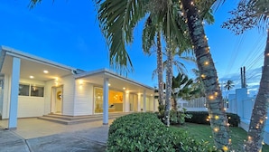 A two-story house with a covered porch, palm trees, and string lights. - Zaba Beach House (San Andrés)