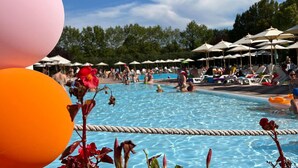 Een zwembadgedeelte met meerdere parasols en ligbedden.
