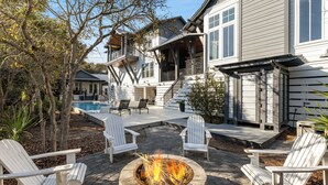 A backyard with a fire pit, outdoor seating, and a pool. - Luxury Home + Carriage House - Heated Pool Oasis (Santa Rosa Beach)