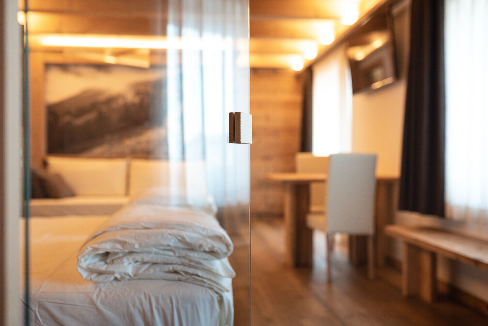 A hotel room with a bed, a desk, and a chair.