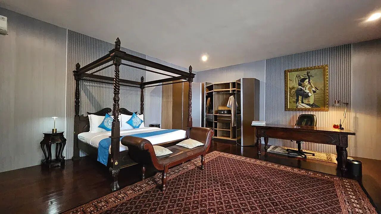 Un lit à baldaquin, une table de chevet, une chaise, une armoire et un tableau accroché au mur.