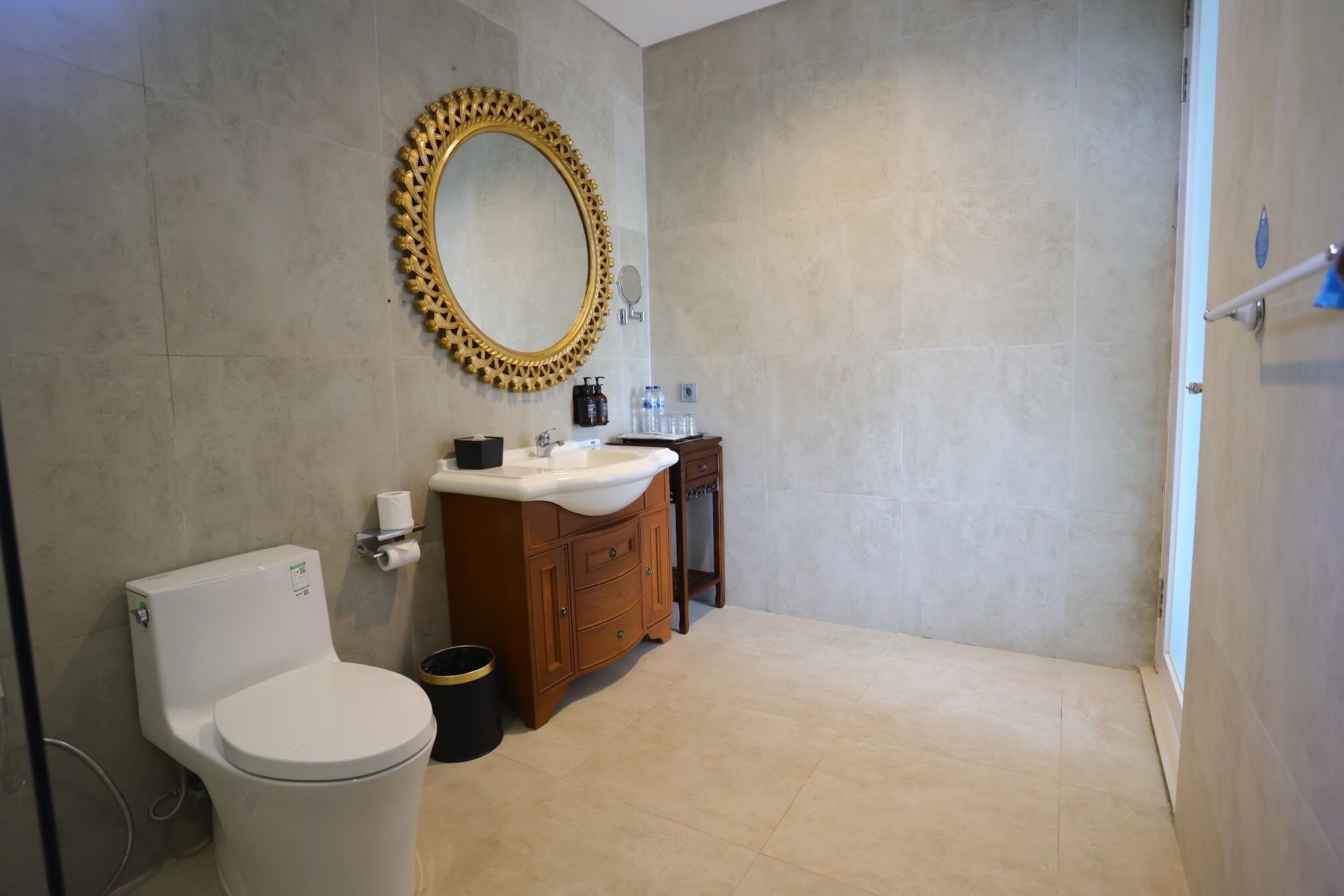 A bathroom with a toilet, vanity, and a large mirror.