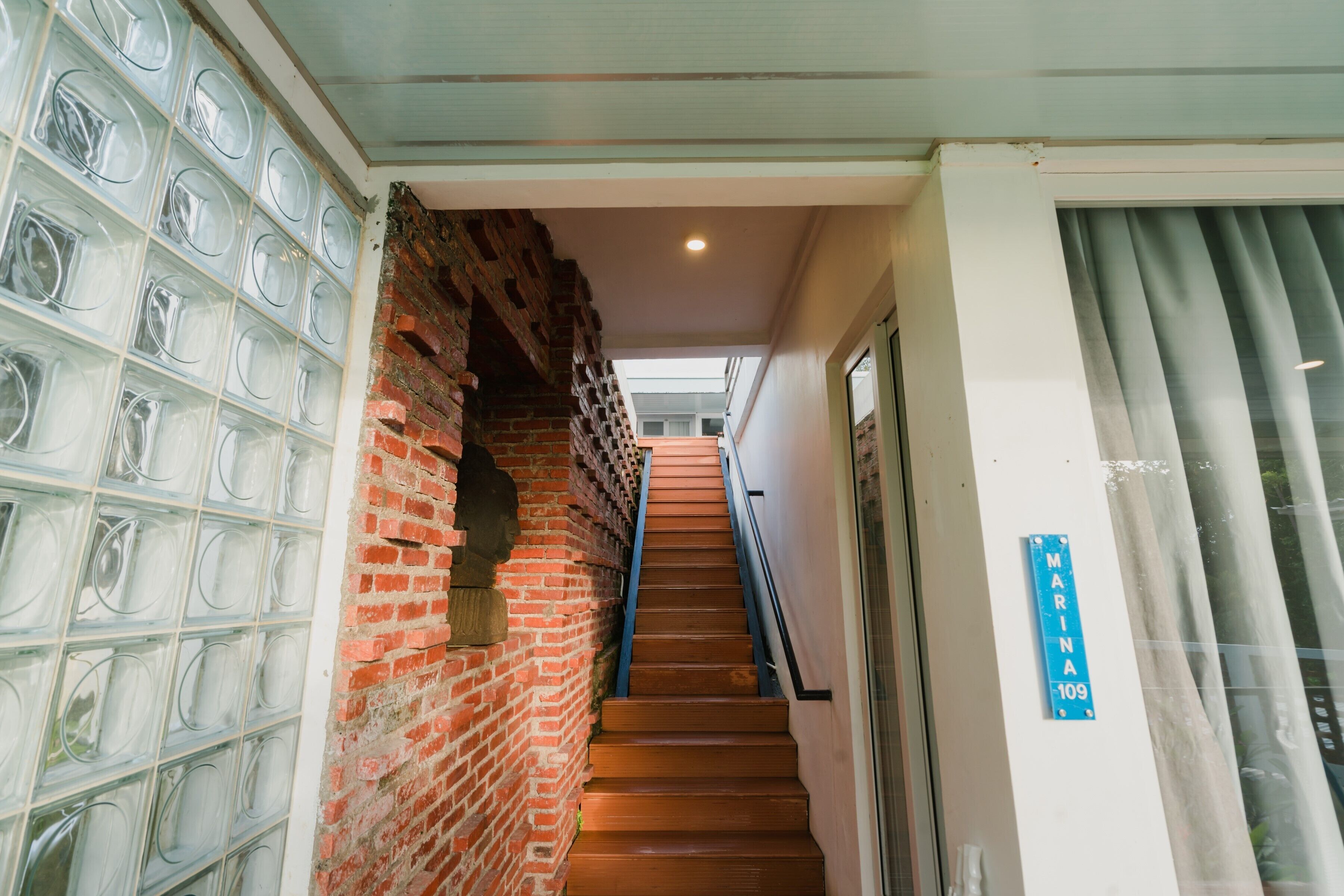 A staircase with a brick wall on one side and a glass block wall on the other.