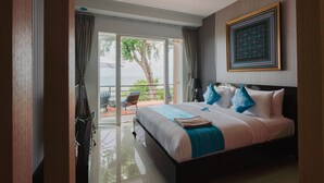 Una habitación de hotel moderna con una cama grande, un balcón con vistas y un elemento decorativo en la pared.