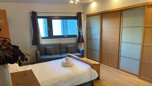 Ein Schlafzimmer mit einem Bett, einer Couch, einem Holztisch und einer Schiebetür.
