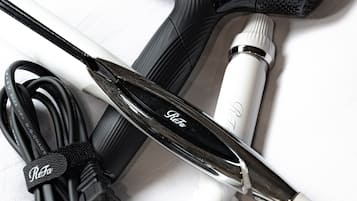 A hair dryer and a curling iron with a power cord.