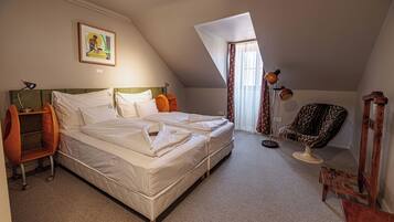 A bedroom with a bed, a chair, a desk, and a painting on the wall.